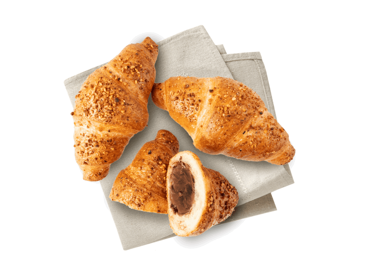Drei mit Nüssen bestreute Croissants, eines davon mit Schokoladenfüllung, liegen auf einem Stoffservietten.