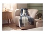 Cozy living room with a beige armchair, a blue and white striped throw, and a wooden side table.