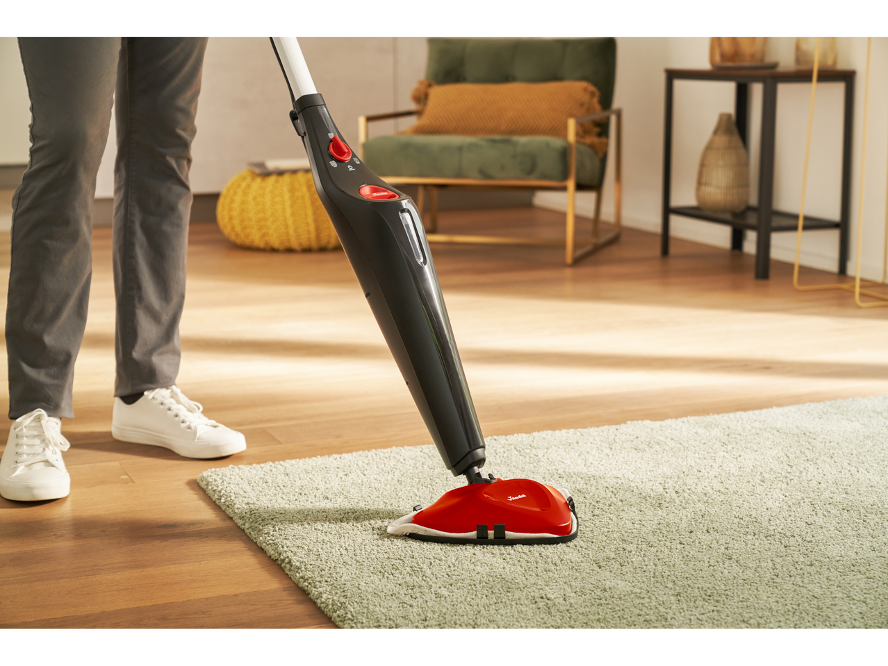 Vileda Steam One steam mop cleaning a rug in a living room.