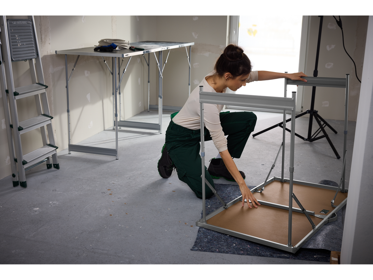 Žena sklapa PARKSIDE® multifunkcionalni sto u sobi tokom renoviranja.