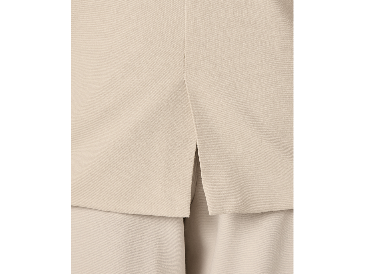 Detalhe das costas de um blazer sem mangas Esmara bege com uma fenda.