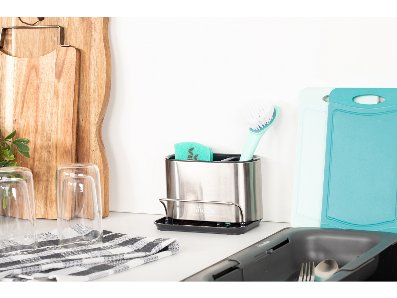 Organizator de chiuvetă Vileda cu burete și perie, tocătoare și pahare alături.