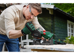 A man uses a Parkside chainsaw sharpener outdoors.