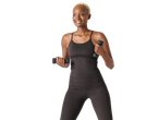 Smiling woman in CRIVIT functional tank top and leggings, holding dumbbells.