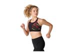 Woman in a black and red patterned sports bra and black leggings, running.