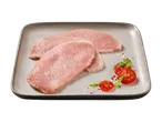 Rohe Schweineschnitzel auf einem Teller mit Tomaten und Kräutern.