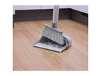 Grey broom and dustpan with collected dust and debris on a wooden floor.