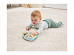 Baby on a white rug playing with a colorful learning tablet.