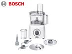 White food processor with various attachments, including blades and discs.