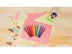 Colourful pens and paper on a wooden surface, with a pen holder.