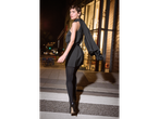 Woman in black esmara® thermal leggings and dress, looking over her shoulder at night.