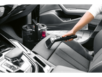 Mulher a limpar um banco de carro com um aspirador de estofos e carpetes Cleanmaxx.