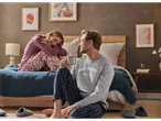 A couple in Esmara pyjamas, a woman in patterned pants and a man in a 'Good Morning' shirt.