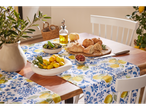 Table set with bread, olives, and lemons; lemon-patterned table runner.