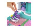 Hand interacting with a purple toy toilet in a dollhouse bathroom with a cat figure in a tub.