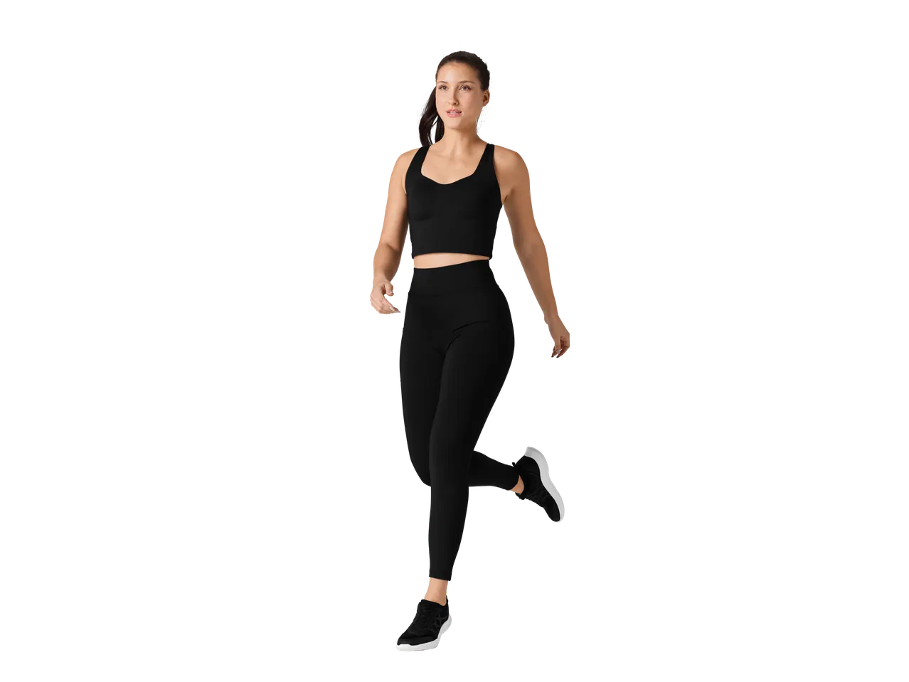 Femeie în sutien sport și leggings negri, fără cusături, alergând.