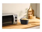 Microwave oven, popcorn maker, and popcorn kernels on a wooden counter.