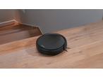 Aspirator robot SILVERCREST® negru pe podea de lemn, lângă scări