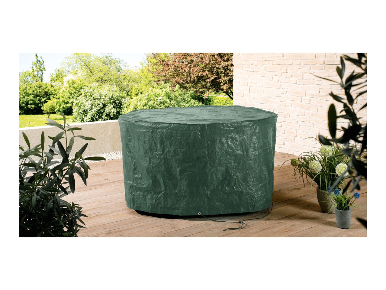 A dark green round patio table cover sits on a wooden deck.