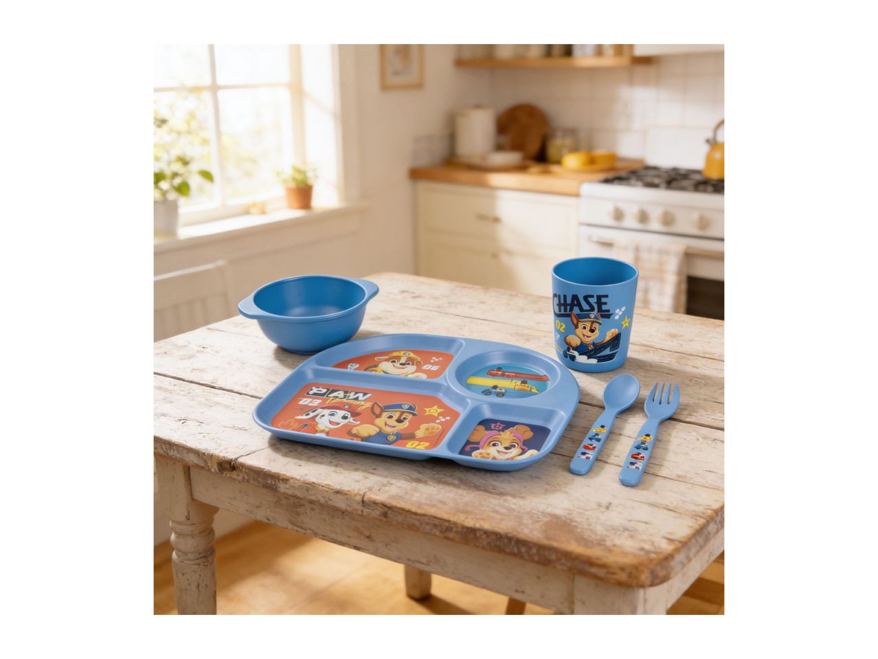 Blue children's dining set with cartoon dog characters, including a plate, bowl, cup, spoon, and fork, on a wooden table.