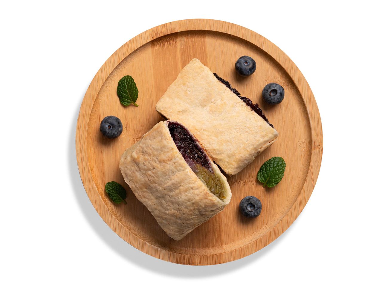 Két töltött sütemény áfonyával és mentával egy fa tálcán.