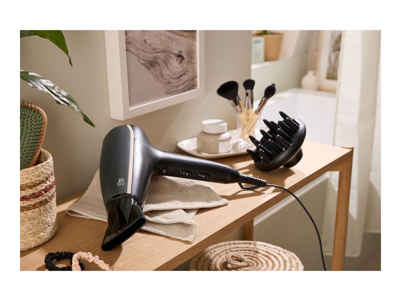 Hair dryer with diffuser and hairbrush on a wooden shelf in a bathroom setting.