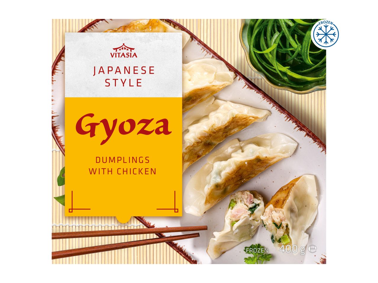 Japanese style chicken gyoza dumplings on a plate with chopsticks and a side of greens, frozen.