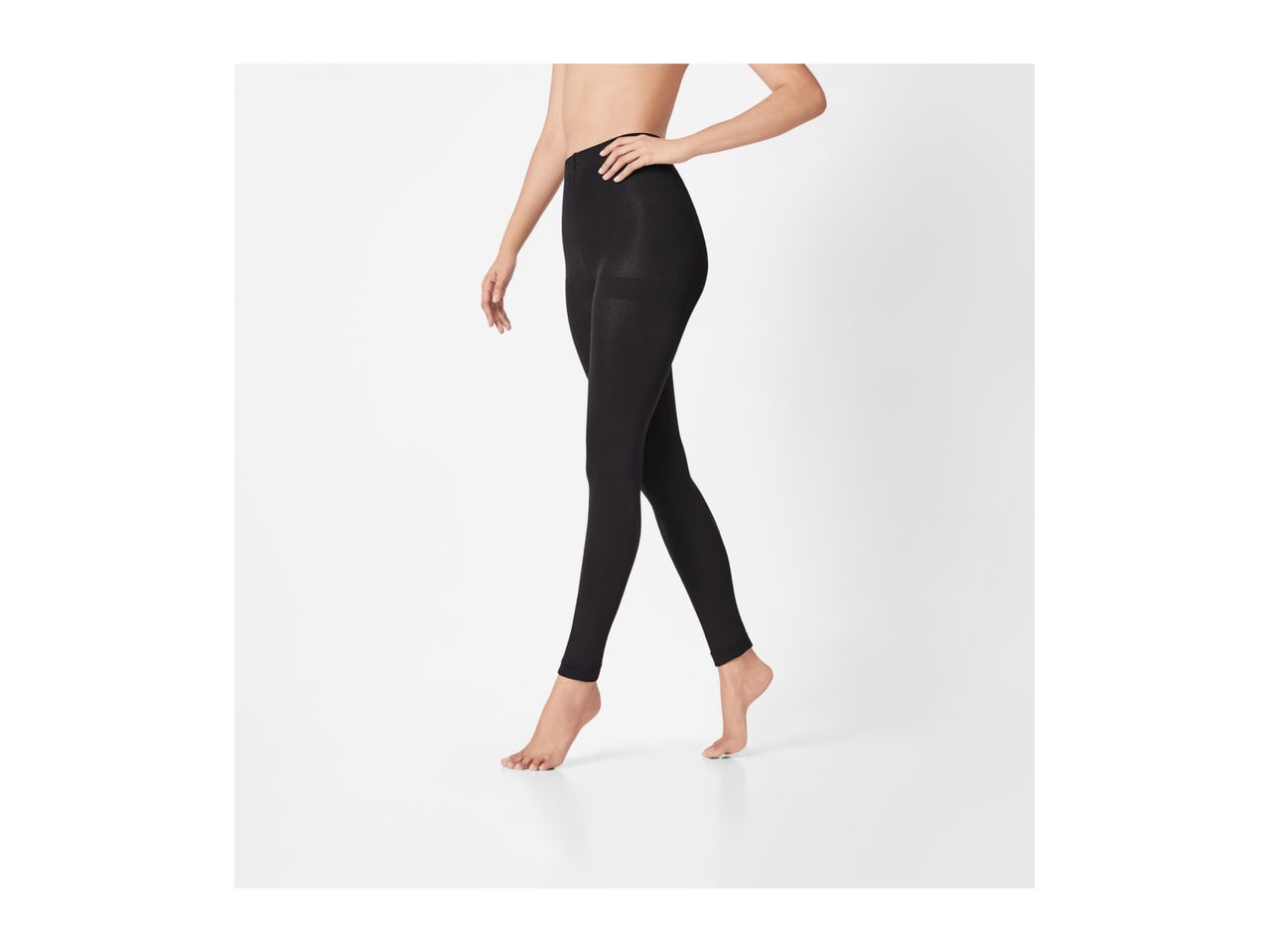 Woman wearing black leggings, standing barefoot on a white background.