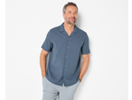 Man wearing a blue Esmara seersucker casual shirt and striped trousers, hands in pockets.