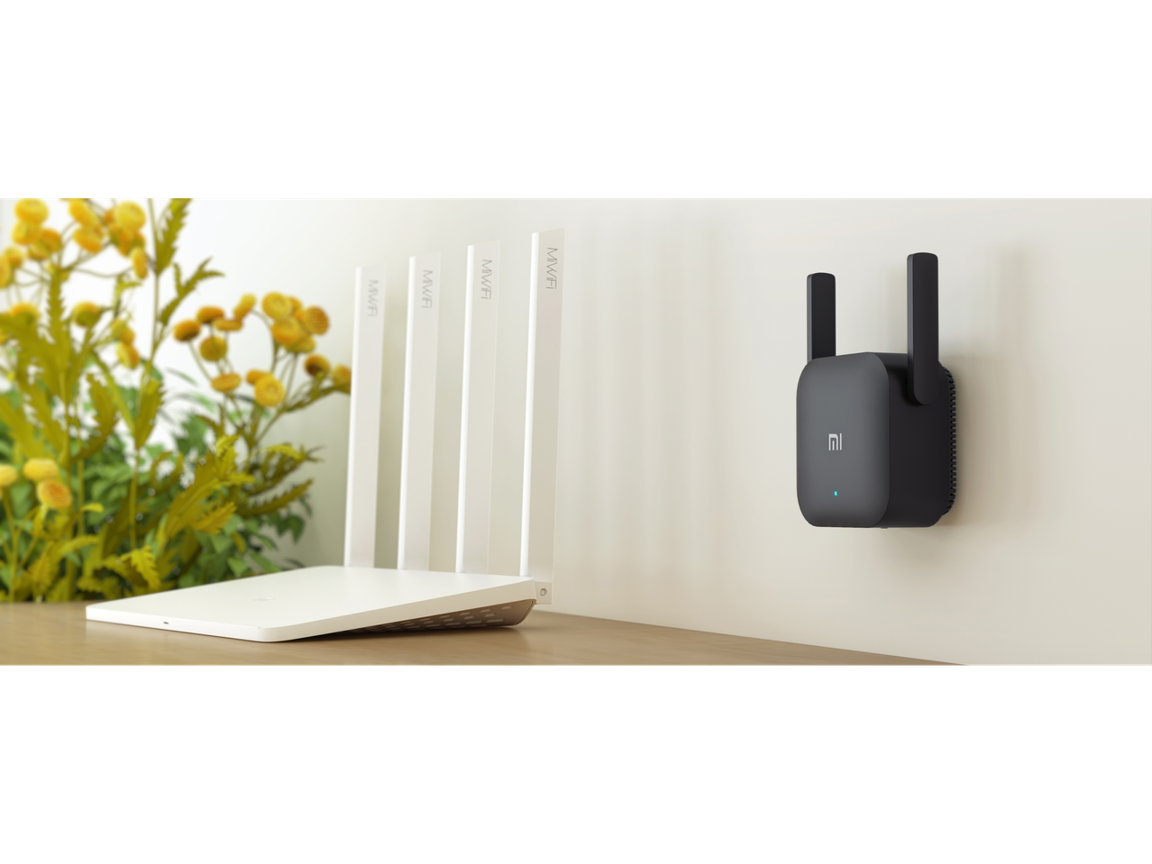 Xiaomi Mi Wi-Fi Range Extender Pro i bijeli ruter na stolu.