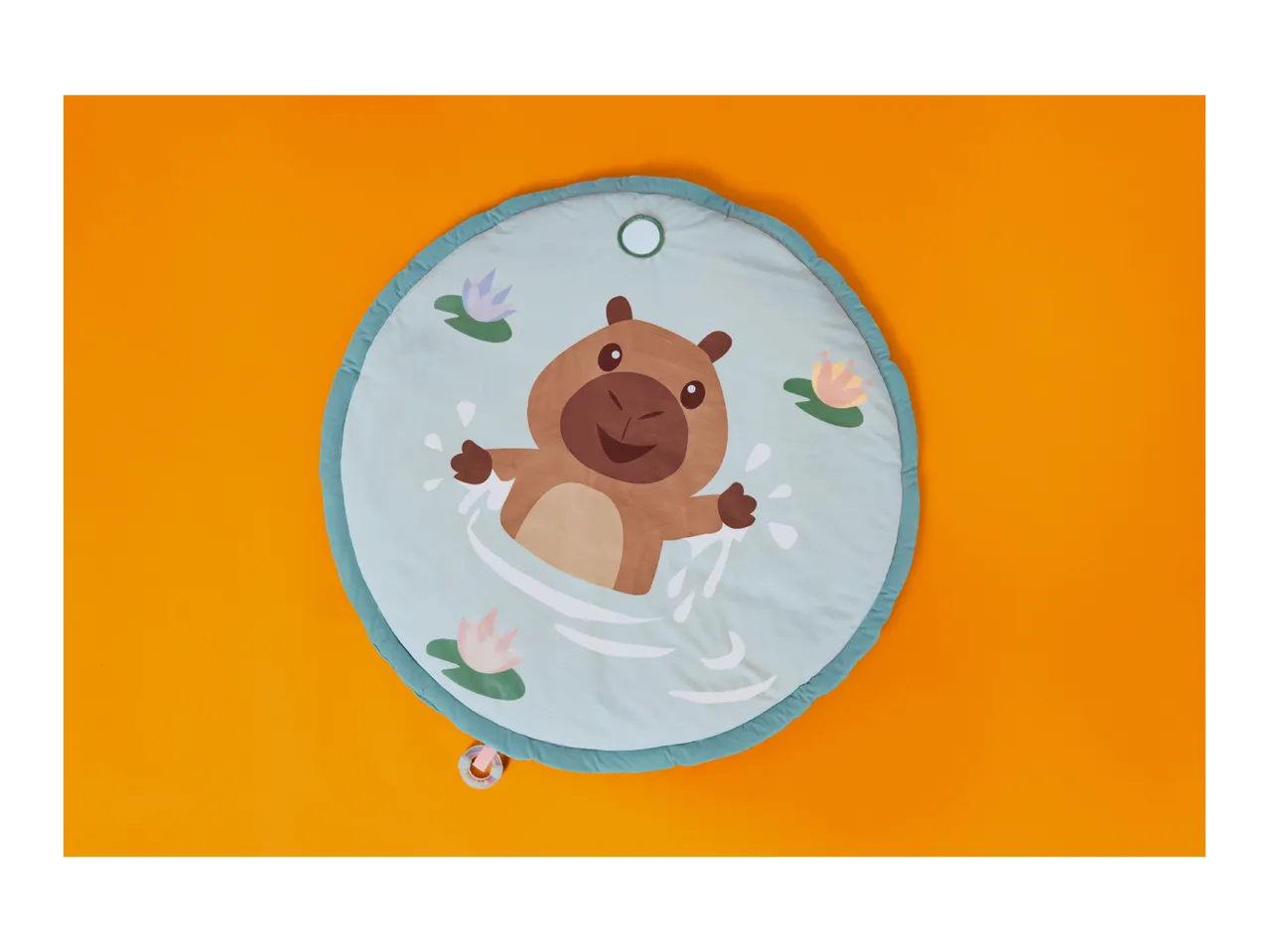 Round baby playmat with a capybara in water surrounded by water lilies.