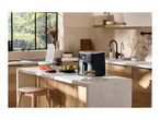 A modern kitchen island with an air fryer, salad, and food chopper, bathed in natural light.