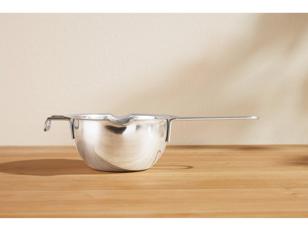 Sită de făină/vas de topire SILVERCREST® din oțel inoxidabil pe o masă de lemn.