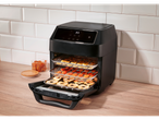 Black air fryer with digital display dehydrating fruit.