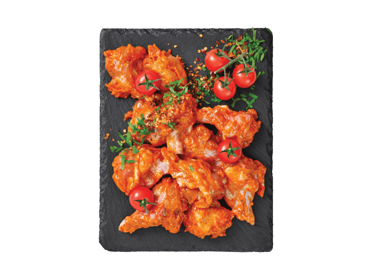 Vürtsikad kanatiivad tomatite ja ürtidega mustal serveerimisalusel.