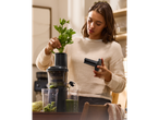 Woman using a SILVERCREST® Premium Slow Juicer to make celery juice.