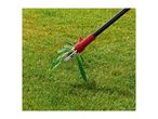 Weed puller removing a weed from a green lawn.