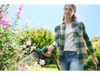 Woman watering flowers with a Gardena hose.