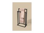 Black metal towel rack with two beige towels hanging on it.
