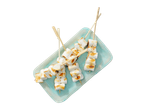 Geroosterde marshmallows op houten spiesjes op een lichtblauw bord.