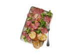 Italiamo Strolghino Pork Salami with bread, cheese, and greens on a platter