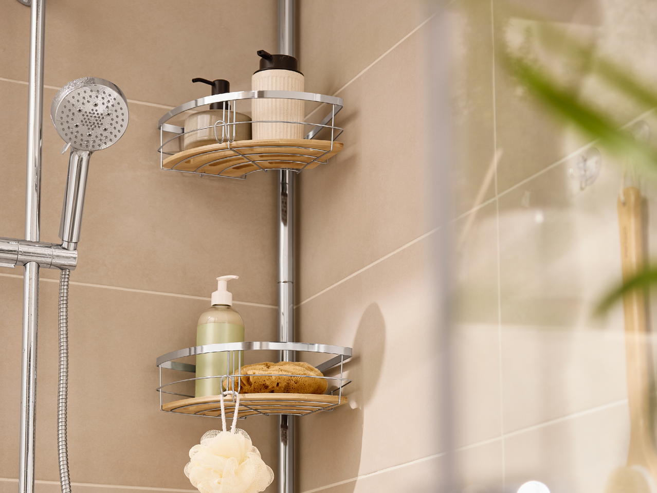 Хромирана етажерка за баня с душ слушалка, бутилки с дозатор и гъби за баня.