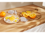 Orange popsicles and sliced oranges on a wooden cutting board, with reusable popsicle molds.