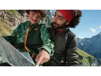 Father and son hiking, looking at a map. Son wears a green CRIVIT jacket.