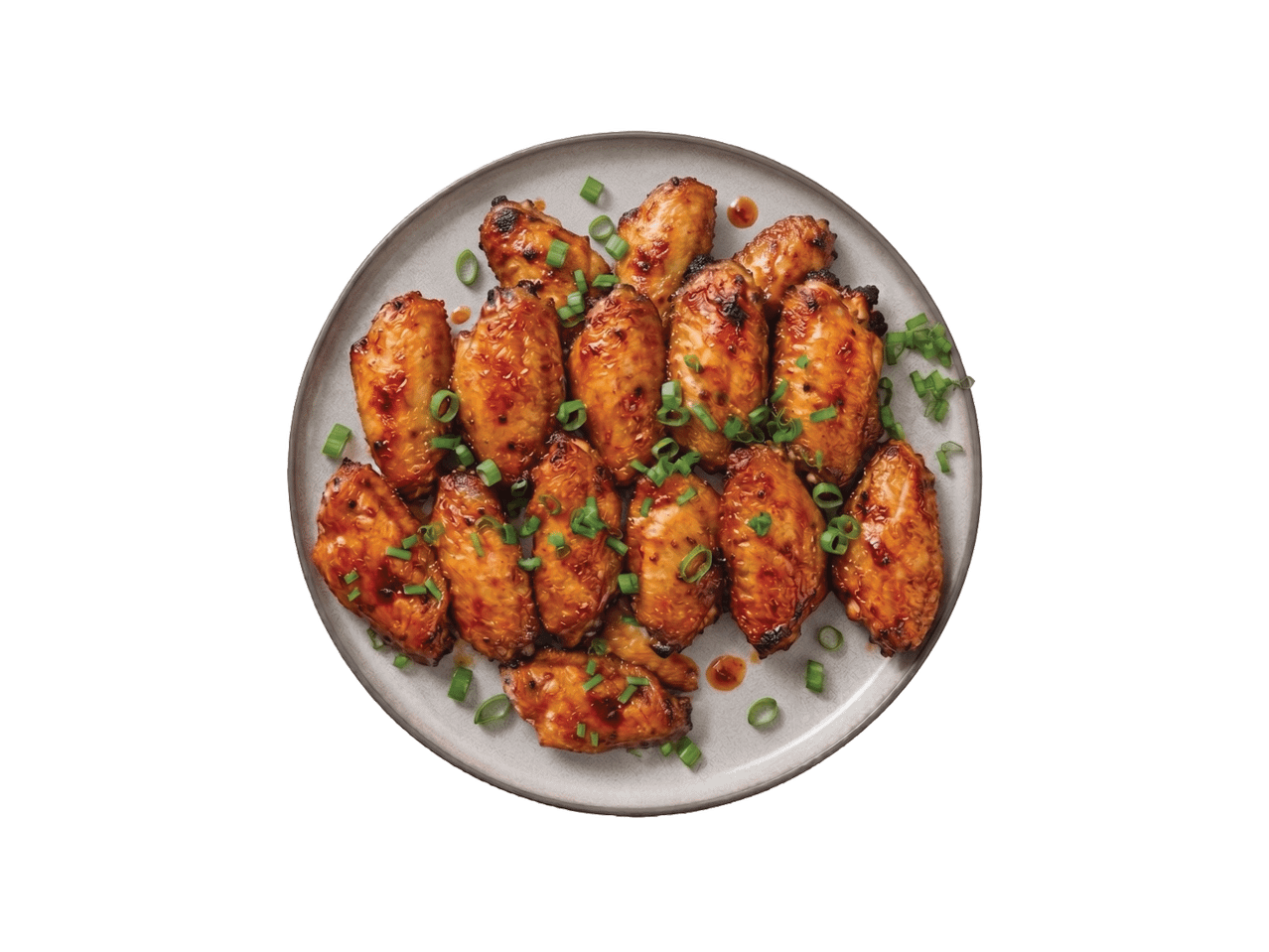 Taldrik teriyaki kastmes kanatiibadega, kaunistatud rohelise sibulaga.