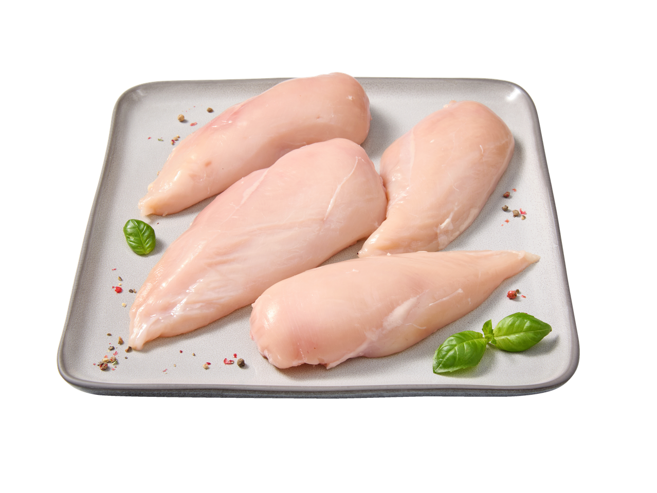 Quatro peitos de frango crus num prato cinzento, guarnecidos com manjericão e pimenta.