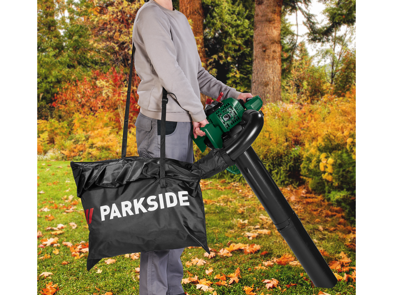 Person using a PARKSIDE leaf blower with a leaf bag in an autumn garden setting.