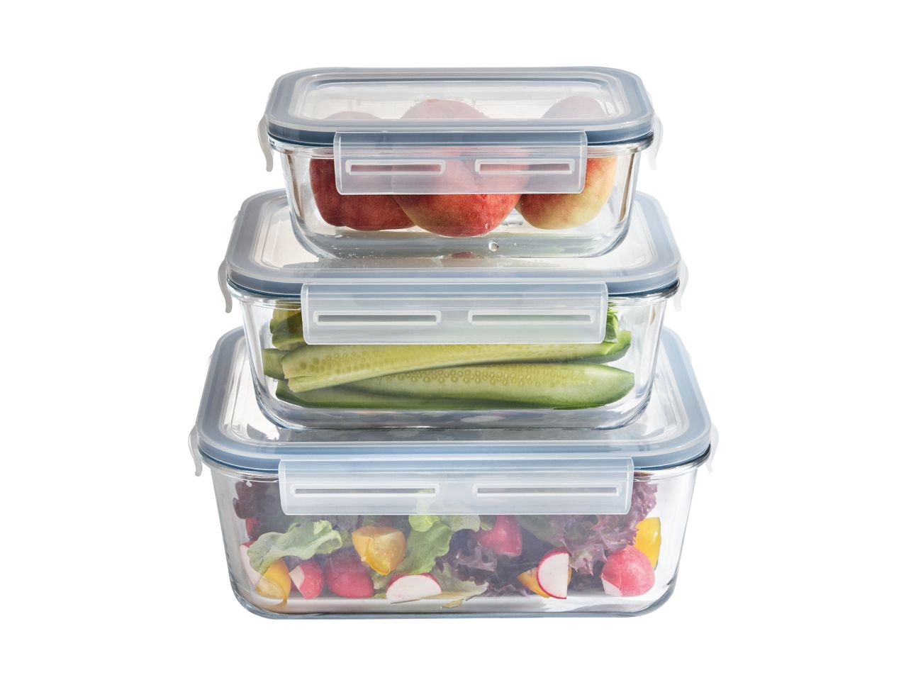 Stabel af tre glasbeholdere med låg, fyldt med frugt, agurker og salat.