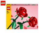 Two red roses made of building blocks on a pink background, with product packaging.
