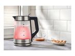 Glass kettle with red illuminated water, next to a bowl of cookies and a glass cup.